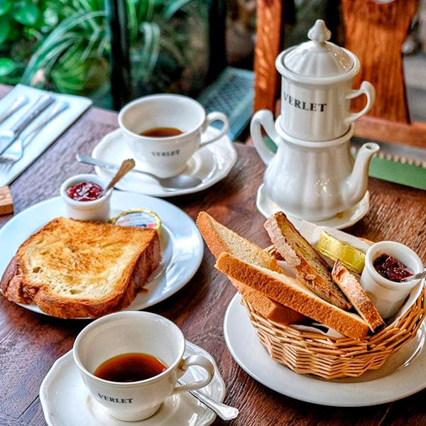 Petit-déjeuner traditionnel chez Verlet à Paris avec tartines, confitures et thé dans une ambiance chaleureuse.